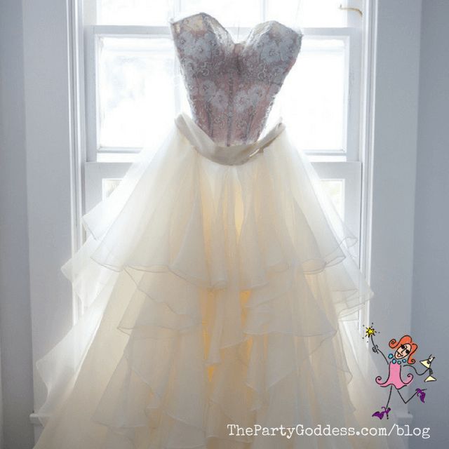 a dress hanging on a window sill in front of a white wall and windowsill