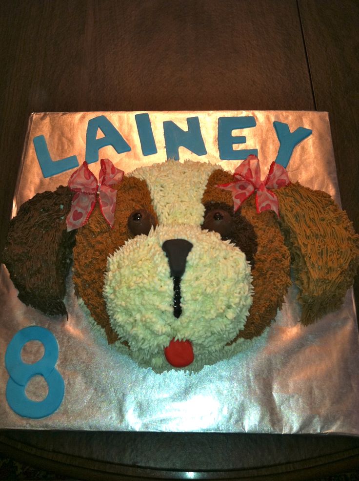 a birthday cake with a dog's face on it and the number 8 is for lainey