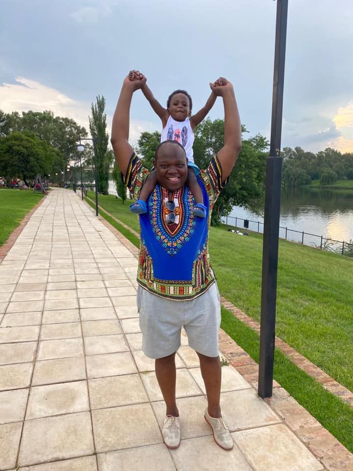 a man holding a child on his shoulders