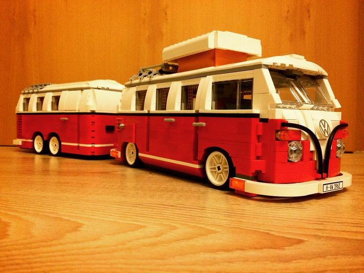 two red and white toy buses sitting on top of a wooden floor next to each other