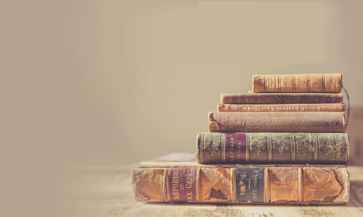 a stack of books sitting on top of a wooden table