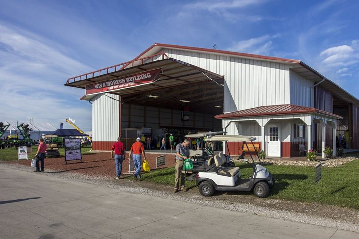 several people standing outside of a building with a golf cart