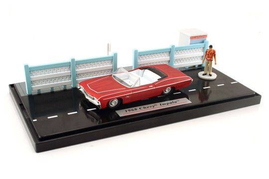 a toy model of a red car with a man standing next to it on a black tray