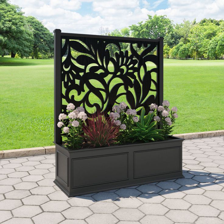 an outdoor planter with flowers and plants in it