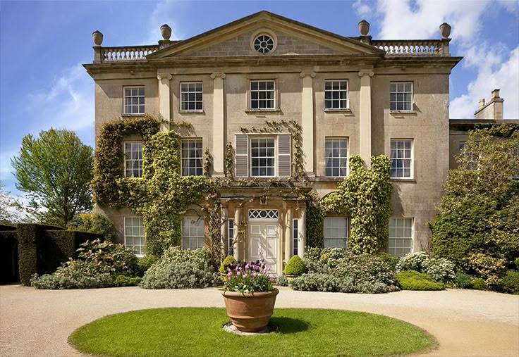 a large house with many windows and plants in the front yard