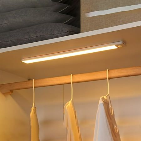 some clothes hanging on a rail in a closet