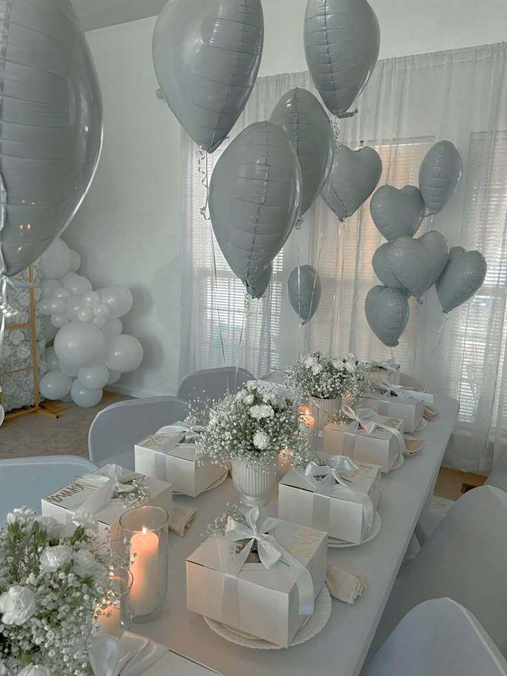 the table is set with many gifts and balloons