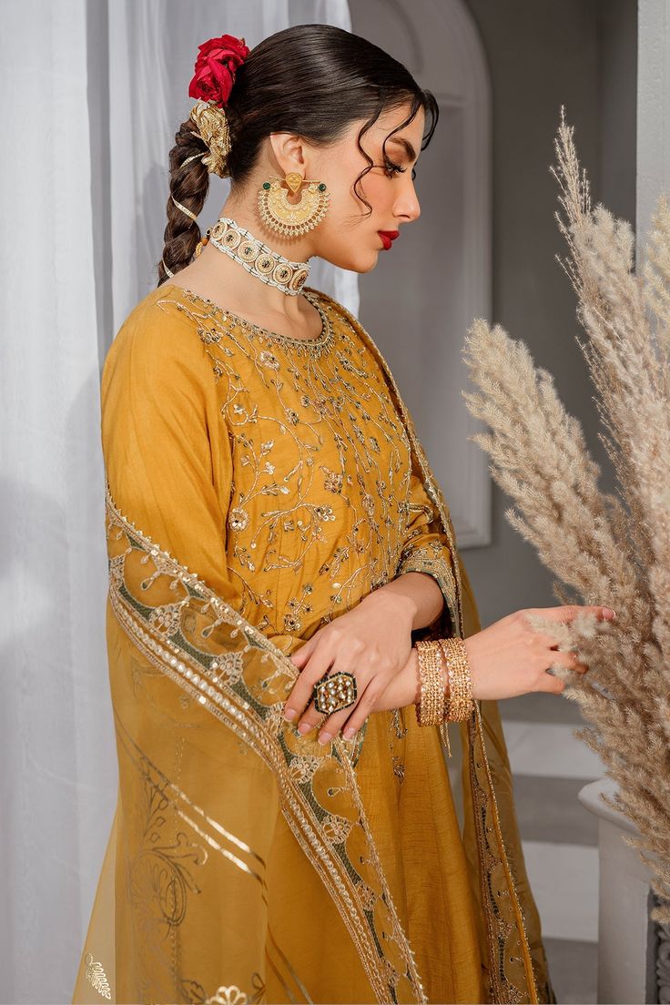 Luxury Mustard Yellow Pakistani Embroidered Salwar Kameez is a simplistic outfit in a mustard shade is crafted on raw silk. The artfully composed neckline, sleeves and hem features, golden embellishments, contrasting color embroidery and lace and tassel detailing, Embroidered Kameez: The beautiful Salwar Kameez comes in a beautiful mustard color and is emblazoned with intricate designs and fine details of embroidery. Floral designs, motifs, and hand-crafted details of sequins, stones, and tilla Yellow Traditional Wear With Mirror Work Straight Kurta, Yellow Traditional Wear Straight Kurta With Mirror Work, Transitional Yellow Churidar With Zari Work, Yellow Raw Silk Churidar For Navratri, Navratri Chanderi Churidar With Gold Embroidery, Transitional Gold Chanderi Kurta, Gold Anarkali Set, Gold Embroidered Chanderi Kurta, Designer Yellow Lehenga With Dabka Detail