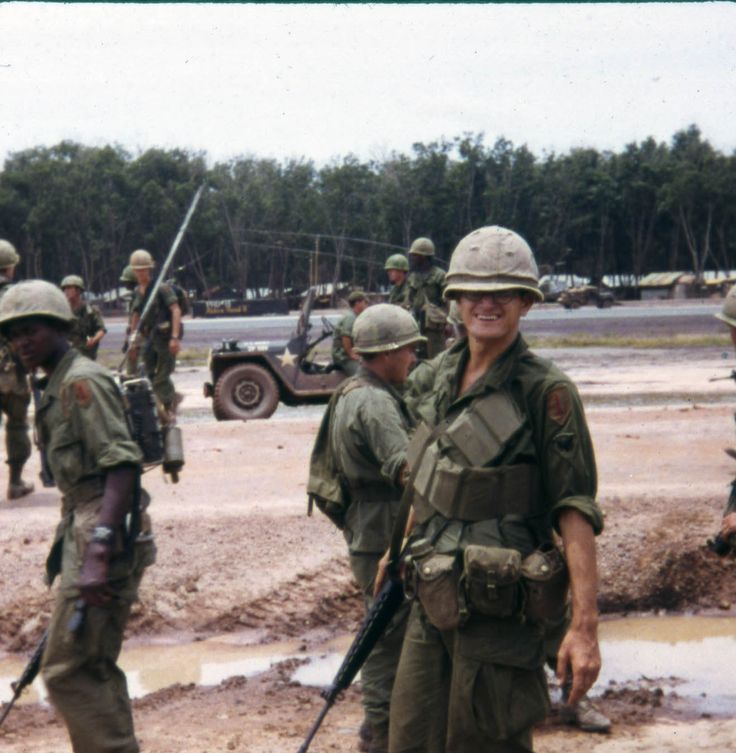 some soldiers are standing around in the mud