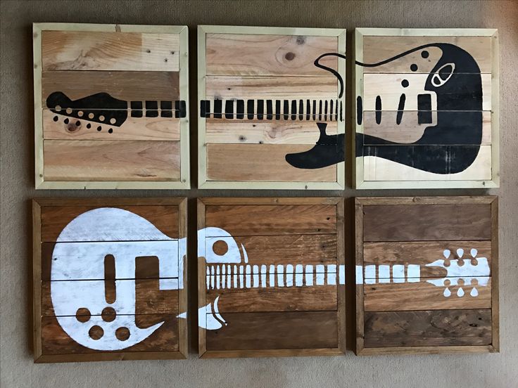 four pieces of wood with guitars painted on them in different shapes and sizes, hanging on the wall