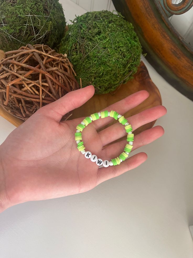 "A green bracelet with the word \"kiwi\" and white pearls" Beaded Bracelets Clay, Kiwi Bracelet, White Clay Bead Bracelet, Clay Bead Bracelet, Green Bracelet, Clay Bead, White Clay, Clay Beads, Lebanon