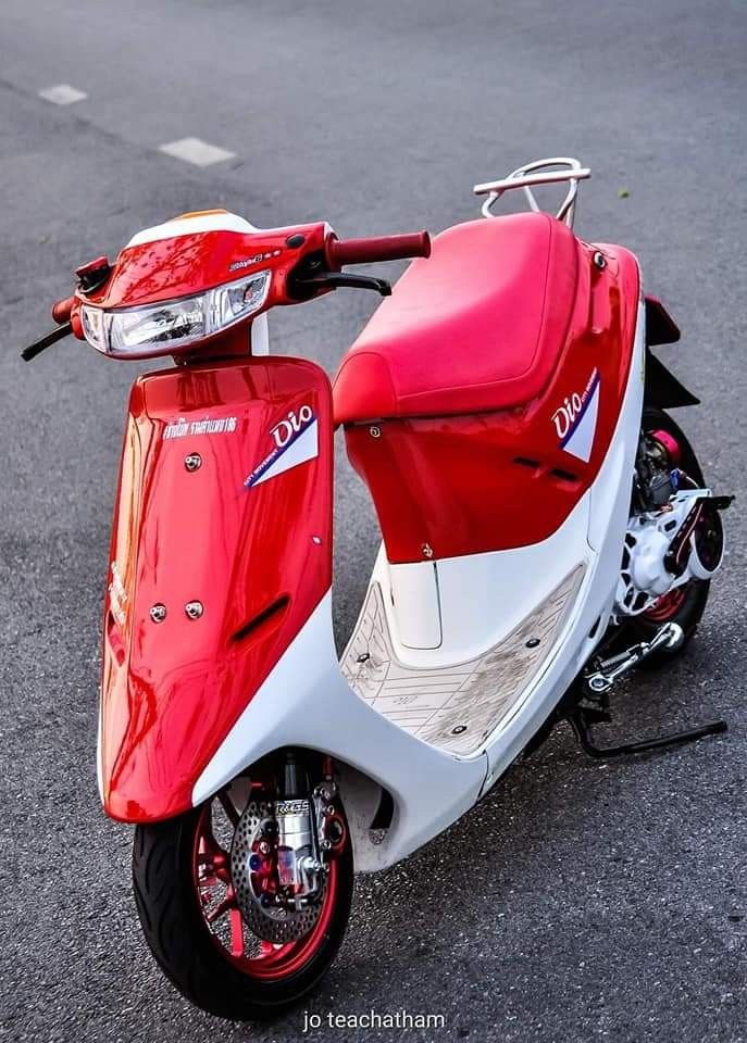 a red and white scooter parked on the street