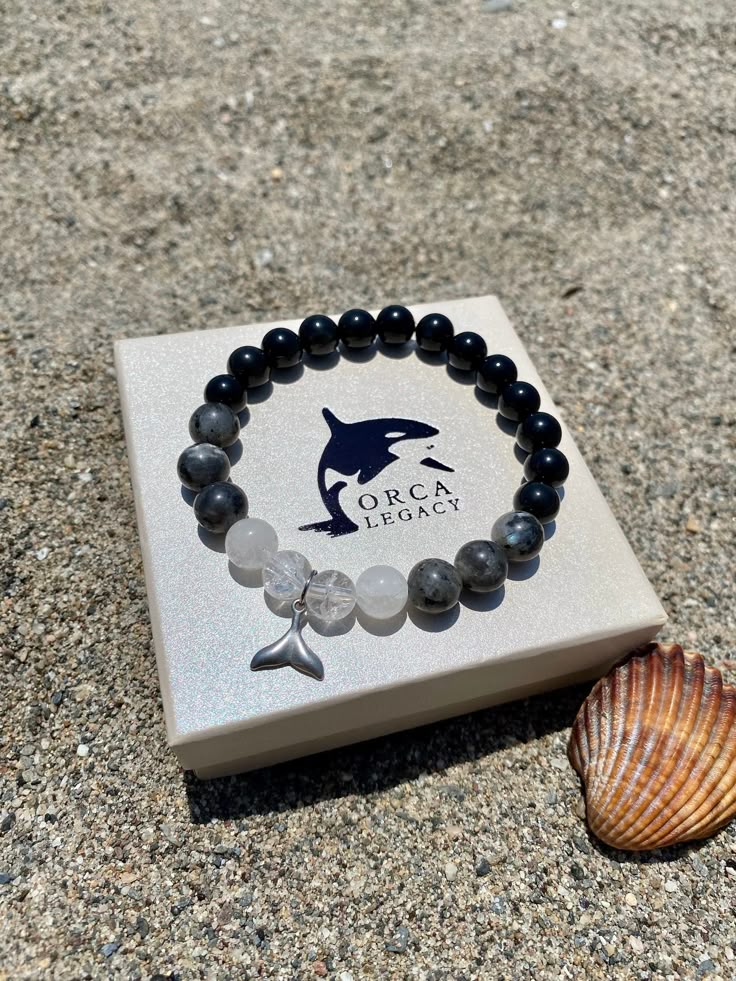 "This Orca bracelet represents the beauty and strength of an orca and is here to fight the captive whale industry and support the creation of a seaside whale sanctuary by The Whale Sanctuary Project. It is made of natural gemstones and a high-quality stainless steel whale tail. It combines the magical power of Obsidian, Labradorit, and Quartz. Wear the Orca bracelet as a symbol of your undying love for orcas as well as proof that you took action and donated. 25% of profits go to The Whale Sanctu Fahlo Bracelet Aesthetic, Orca Accessories, Orca Bracelet, Tiny Woman, Undying Love, Power Stone, Magical Power, Whale Tail, The Whale