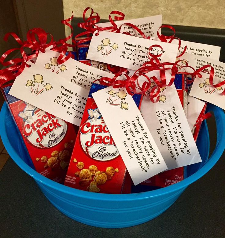 a blue bucket filled with red and white candy bar wrappers next to a note