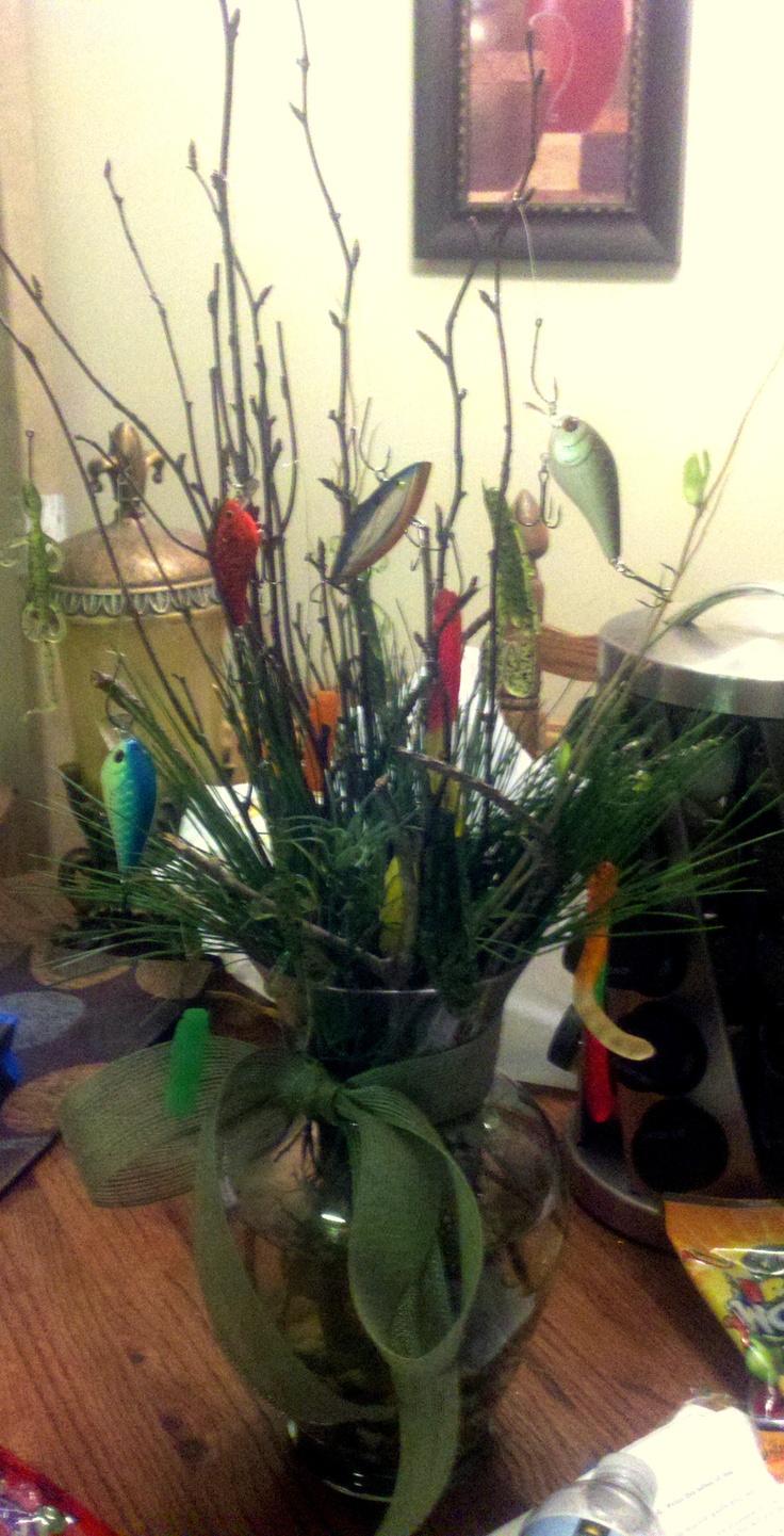 a vase filled with lots of plants on top of a wooden table