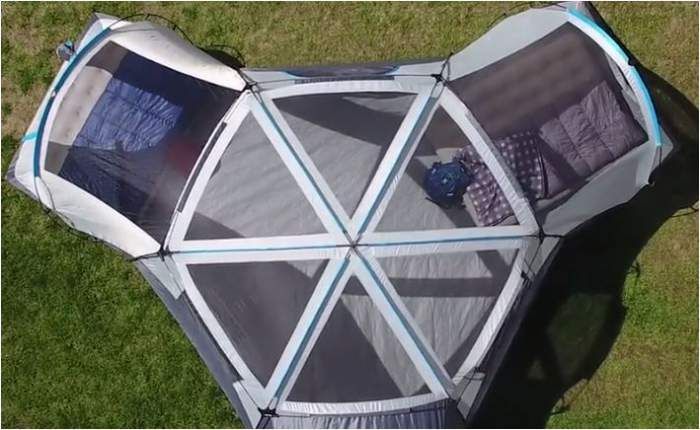 an overhead view of a tent on the grass with its door open and bed in it