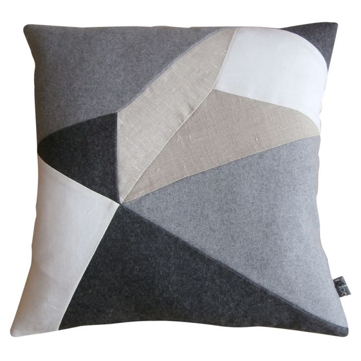 a gray and white pillow with an abstract design