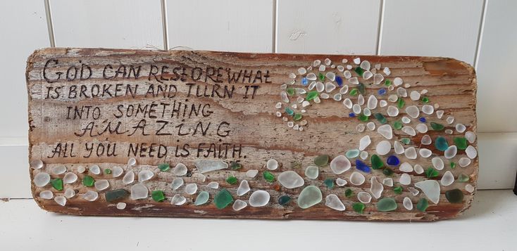 a wooden sign with sea glass on it