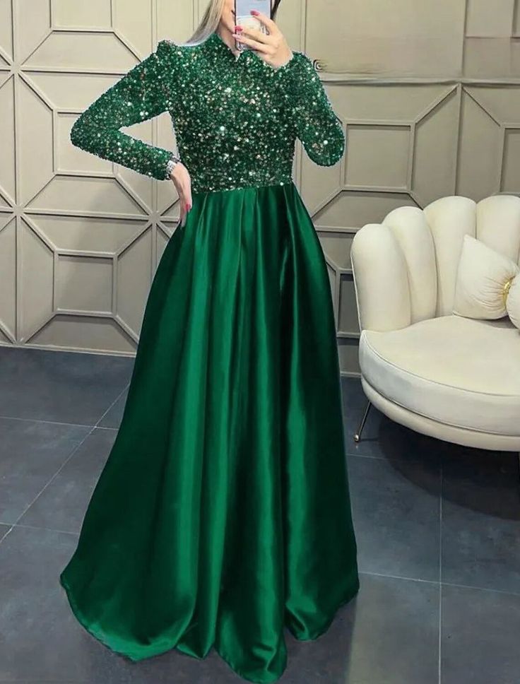 a woman taking a selfie wearing a green dress with sequins on it