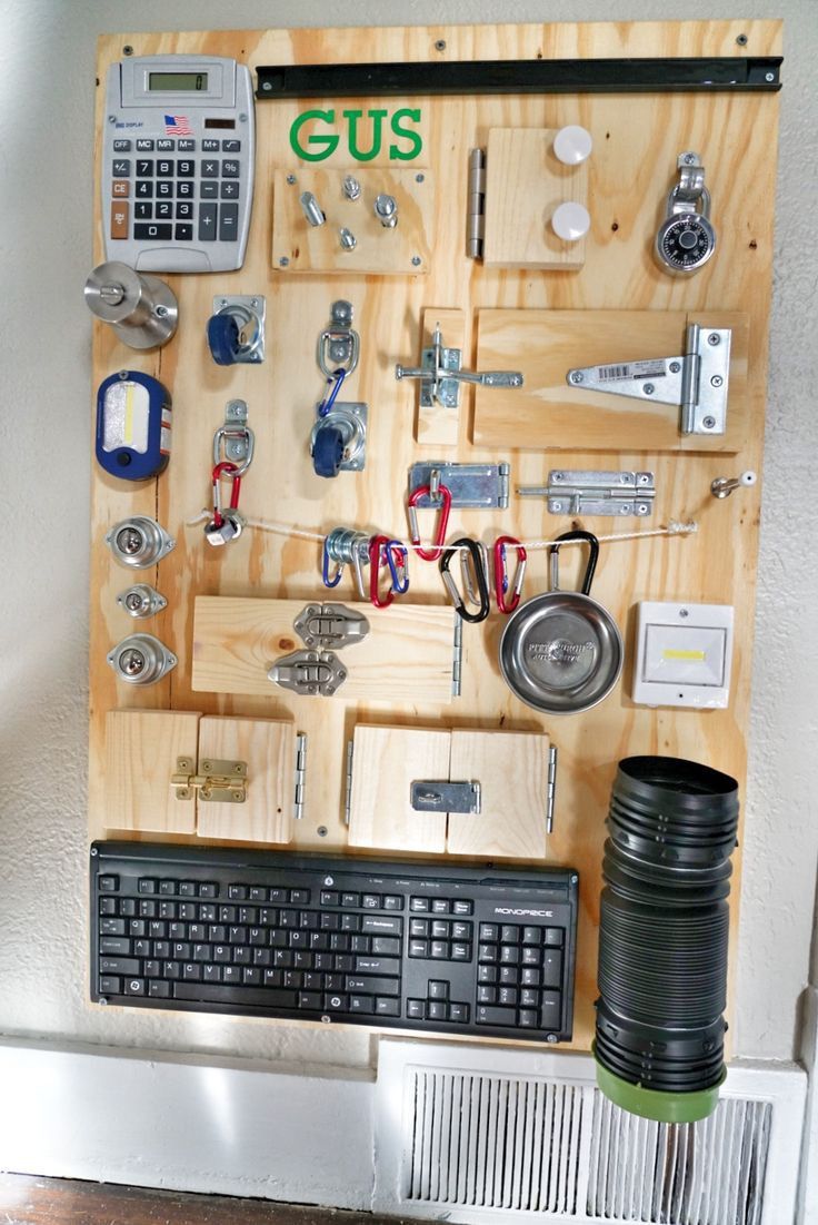 a computer keyboard sitting on top of a wooden board covered in magnets and keys