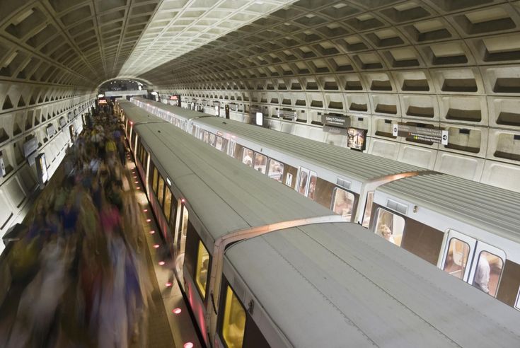 people are riding on the subway cars in an underground train station with many windows and doors