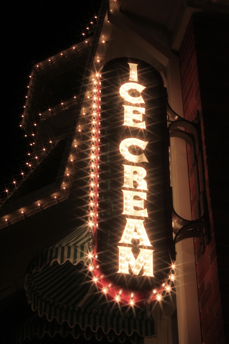 the sign is lit up with christmas lights in front of a building that says california