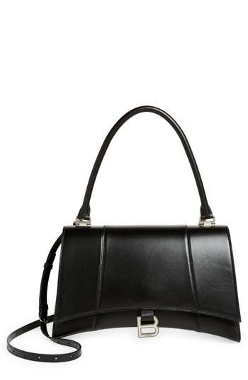 The curvilinear silhouette of this smooth leather satchel recalls the exaggerated shapes and proportions often used by master couturier Cristóbal Balenciaga. B-shaped hardware reveres the brand's legacy while keeping with the current logomania craze. Magnetic-snap flap closure Top carry handle; removable, adjustable crossbody strap Exterior slip pocket Interior zip and wall pockets Structured silhouette with flat base for stability Napa-lambskin lining Leather Made in Italy Designer Handbags Elegant Double Flap Bag For Business, Elegant Double Flap Office Bag, Elegant Business Double Flap Bag, Elegant Double Flap Shoulder Bag, Elegant Leather Bag With Double Flap, Elegant Double Flap Leather Bag, Elegant Office Flap Bag With Double Flap, Elegant Double Flap Bag For Office, Elegant Flap Bag With Palladium Hardware For Work