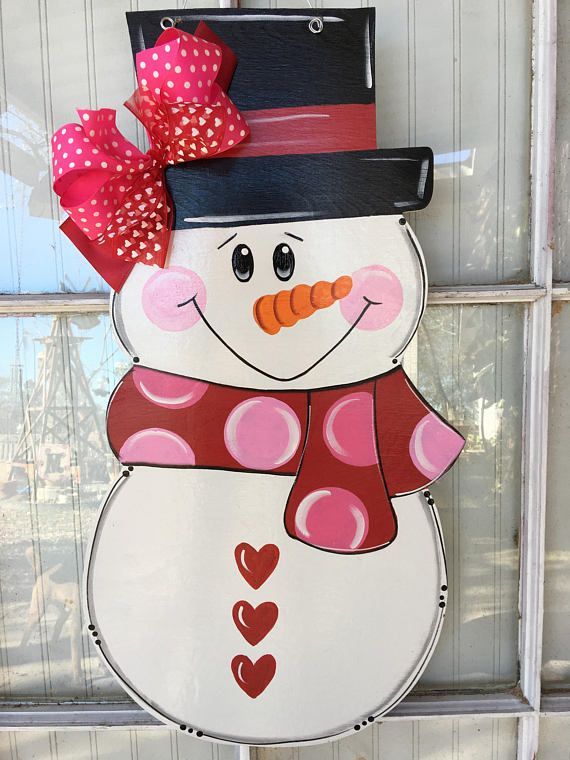 a snowman with a hat and scarf on it's head is standing in front of a window