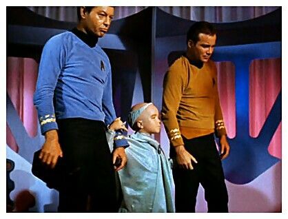 two men are standing next to a small child in a star trek costume on stage