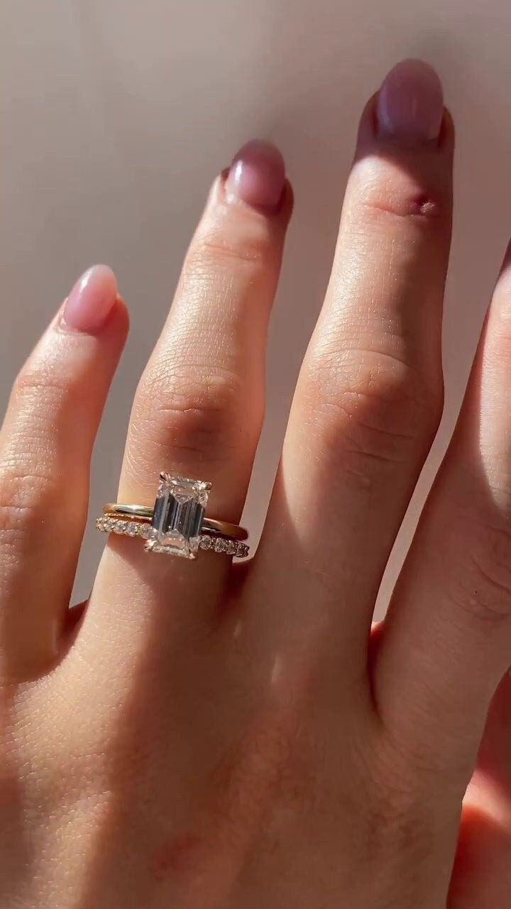 a woman's hand with an engagement ring on top of her finger and two other fingers