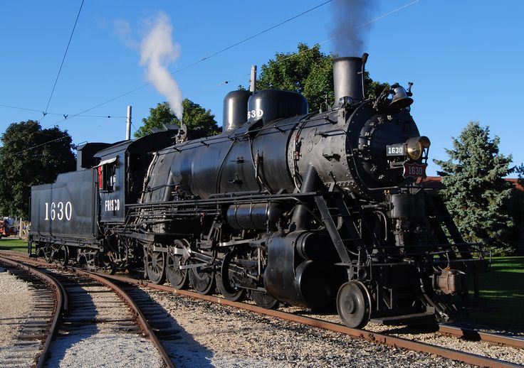 an old fashioned steam engine on the tracks