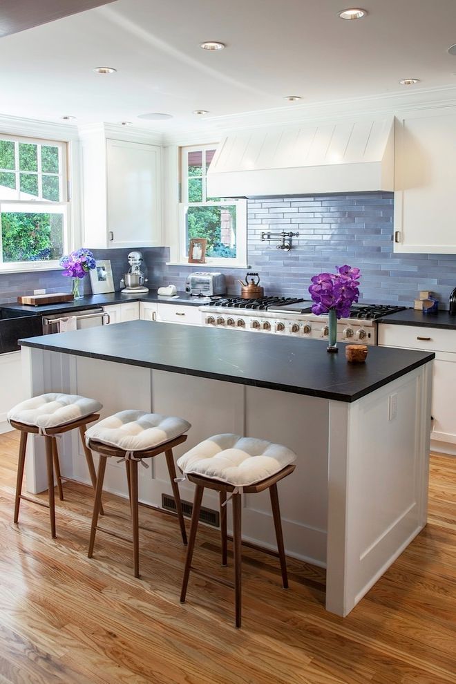 a kitchen with two stools and an island in front of the stove top oven