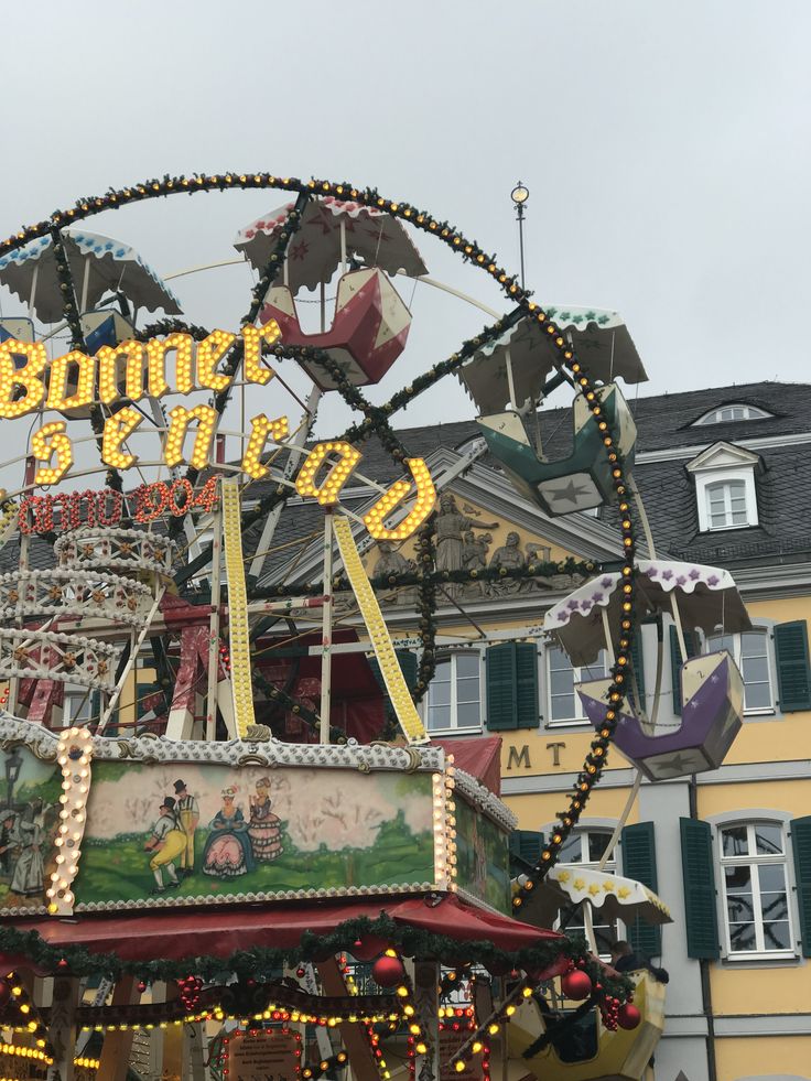 an amusement park with a ferris wheel and merry - go - round sign in the foreground