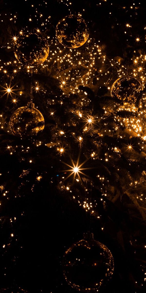 many shiny balls are lit up in the night sky with stars and sparkles on them