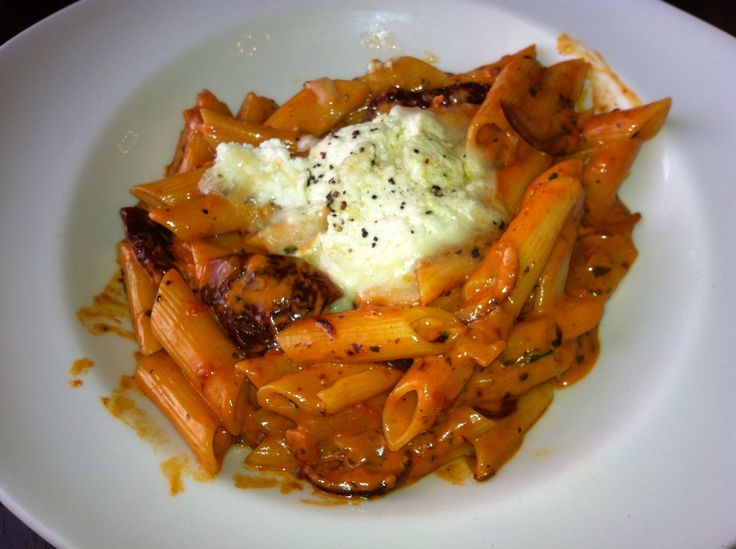 a white plate topped with pasta covered in sauce