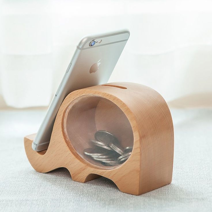 an elephant shaped wooden speaker with a cell phone in it