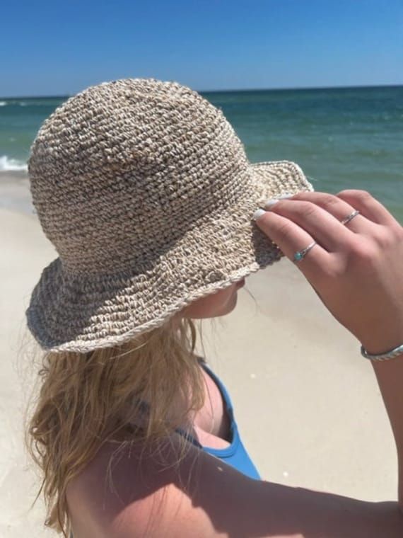 Organic Hemp Crochet Sun Hat  Our handmade crocheted sun hats are made from pure hemp yarn from Nepal. Perfect for summer...at the beach, pool, festival or just hanging around. They come in one size which fits most! As with many 100% hemp products they maybe slightly stiff, but soften and stretch over time. Features:  - 100% Hemp hat and handmade in Nepal  - It has wire in the rim means you can shape the hat however you desire and flat pack it for easy storage or travel.  - One size which fit mo Beach Lightweight Cloche Hat With Flat Brim, Lightweight Cloche Hat With Flat Brim For Beach, Lightweight Flat Brim Cloche Hat For Beach, Adjustable Crochet Hat With Flat Brim, Beach Lightweight Flat Brim Cloche Hat, Bohemian Crochet Hat With Curved Brim For Warm Weather, Woven Yarn Wide Brim Bucket Hat, Wide Brim Woven Yarn Bucket Hat, Beige Handwoven Crochet Hat With Curved Brim