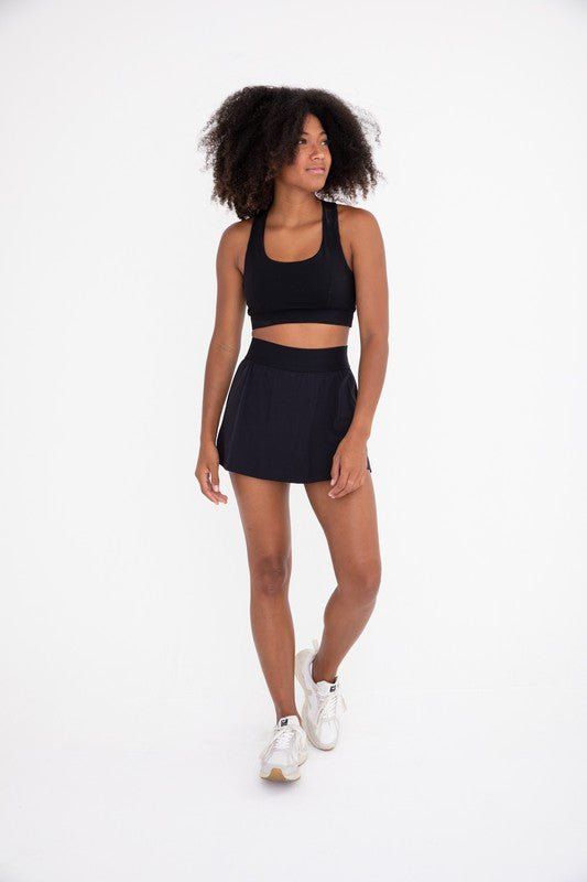 The perfect skirt for on and off the court! It features a seam that swoops all the way around, a thick elastic waistband, and built-in shorts with side pockets. Fabric & fit: 88% nylon 12% spandexMoisture-wickingFour-way stretch Model is wearing size Small. Hiking Leggings, Pole Shorts, Graphic Leggings, Tennis Skort, Clothing Retail, Bootcut Pants, High Rise Shorts, Short Leggings, The Court