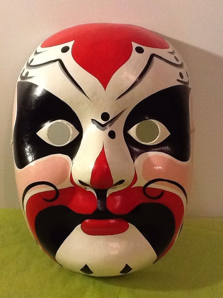 a red and black mask sitting on top of a green table