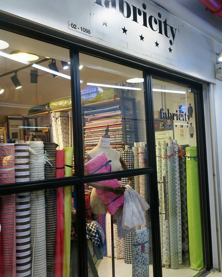 the inside of a clothing store with lots of items on display in front of it