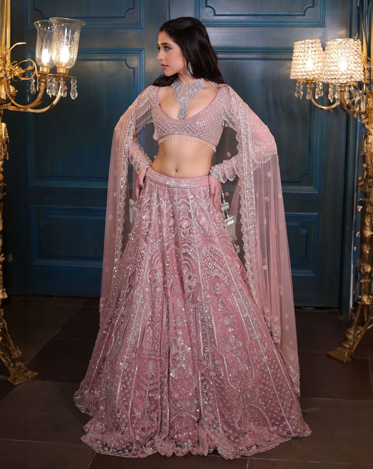 A modern bridal lehenga hand embellished with pearls, crystals, sequin, and cutdana embroidery. Paired with a full sleeves embroidered blouse with all-over dangling tassel detailing on the sleeves and an embroidered cutwork dupatta with a border. Additional dupatta available upon request.DELIVERY TIMEPlease allow 8-12 weeks for your outfit to arrive.FABRIC DETAILSNetProfessional cleaning only. Sequin Lehenga For Eid Reception, Eid Reception Lehenga With Sequins, Hand Embellished Semi-stitched Traditional Wear, Bollywood Style Hand Embellished Lehenga For Eid, Bollywood Style Hand Embellished Sharara For Festive Occasions, Bollywood Style Hand Embellished Festive Sharara, Traditional Sequined Anarkali Set For Receptions, Traditional Anarkali Set With Sequins For Reception, Hand Embellished Semi-stitched Lehenga For Eid