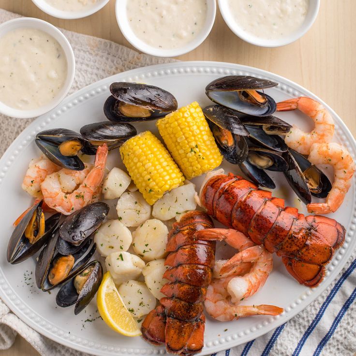 a white plate topped with seafood and corn on the cob