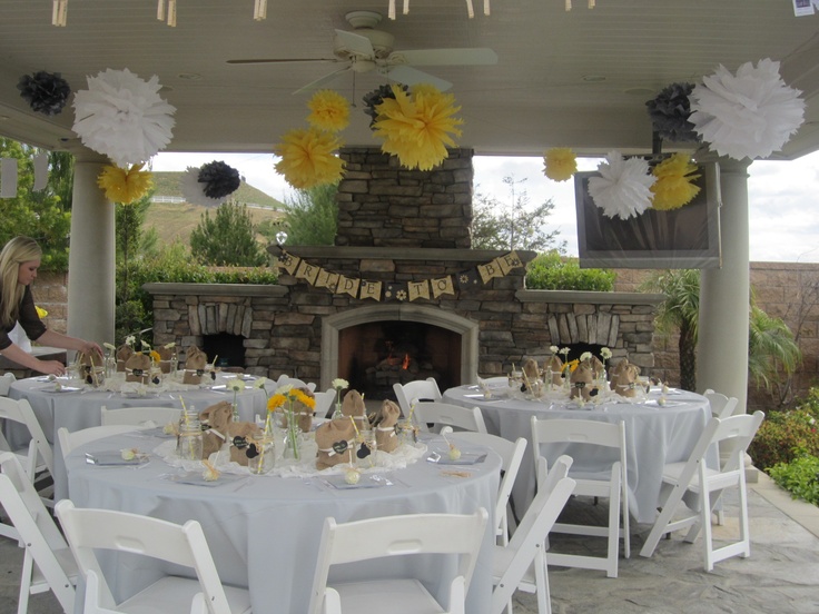 an outdoor dining area with tables and chairs set up in front of a fire place