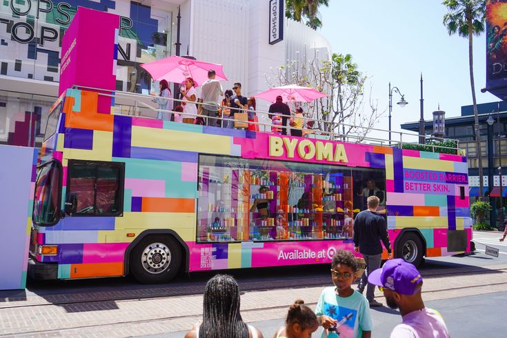 people are standing on the roof of a colorful bus