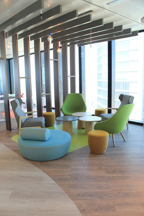 an office lobby with chairs, tables and couches