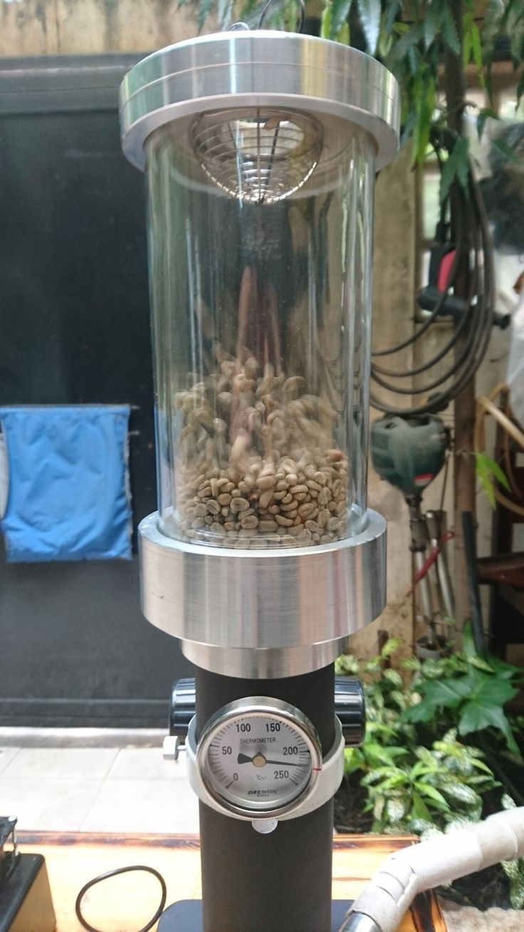 a coffee grinder filled with lots of beans and other things on top of a table