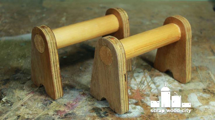 two wooden pegs sitting on top of a floor next to each other in front of a wall