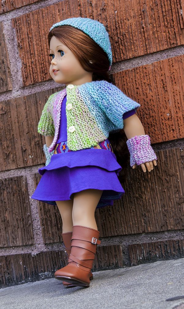 a doll is leaning against a brick wall wearing a purple dress and brown booties