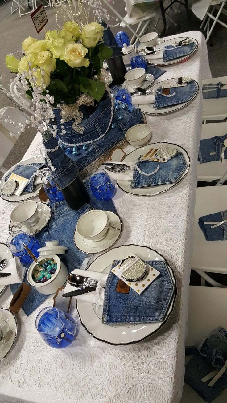 the table is set with blue and white dishes, silverware, and napkins