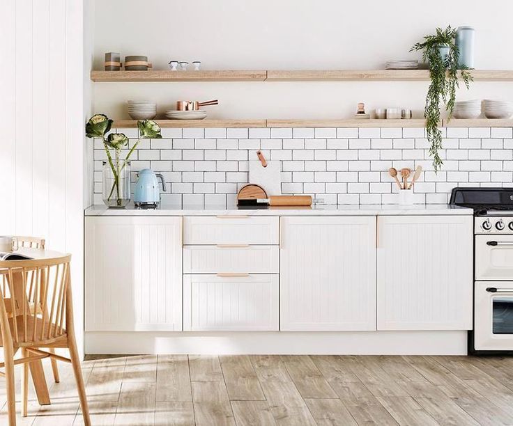 a white stove top oven sitting inside of a kitchen next to a wooden dining table